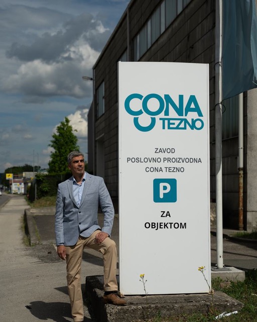 Bor Greiner stoji ob tabli z napisom Cona Tezno.